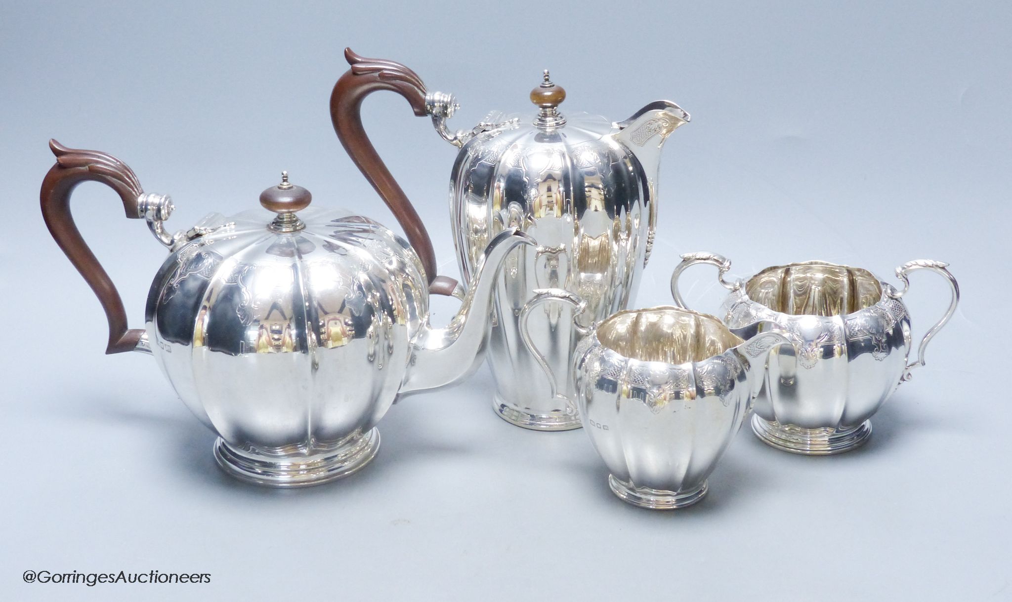 A George V engraved fluted silver four piece silver tea set by Adie Bros, London, 1923,27,28